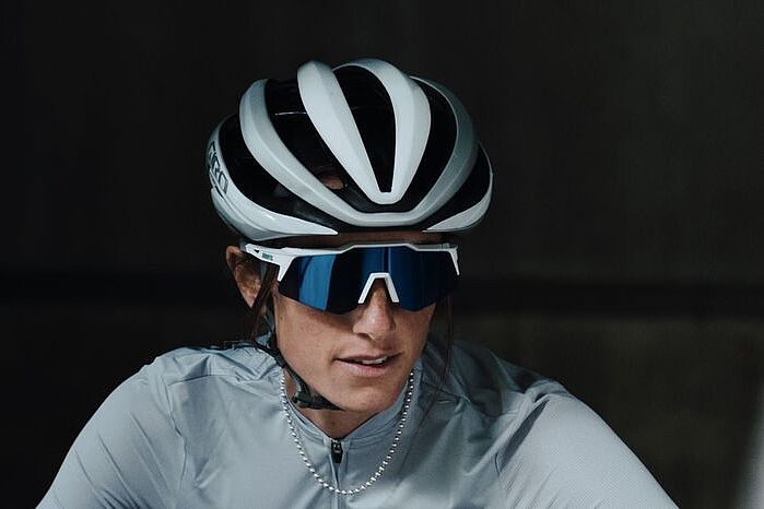 Speedcraft2 Portraitbild einer Frau mit weißem Fahrradhelm und der Speedcraft XS-Brille des Herstellers 100%.